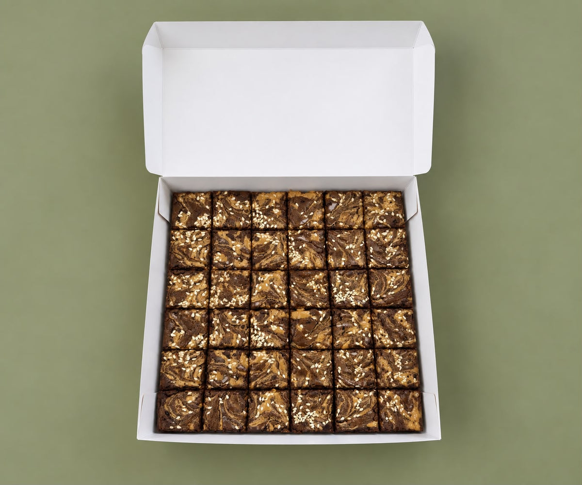 Box of 36 peanut butter and tahini brownie bites with sesame seeds